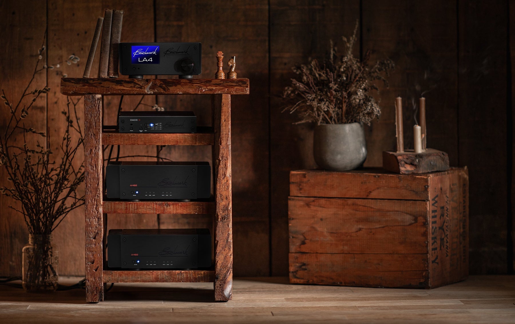 Benchmark amplifiers in a wooden cabinet against a wooden wall
