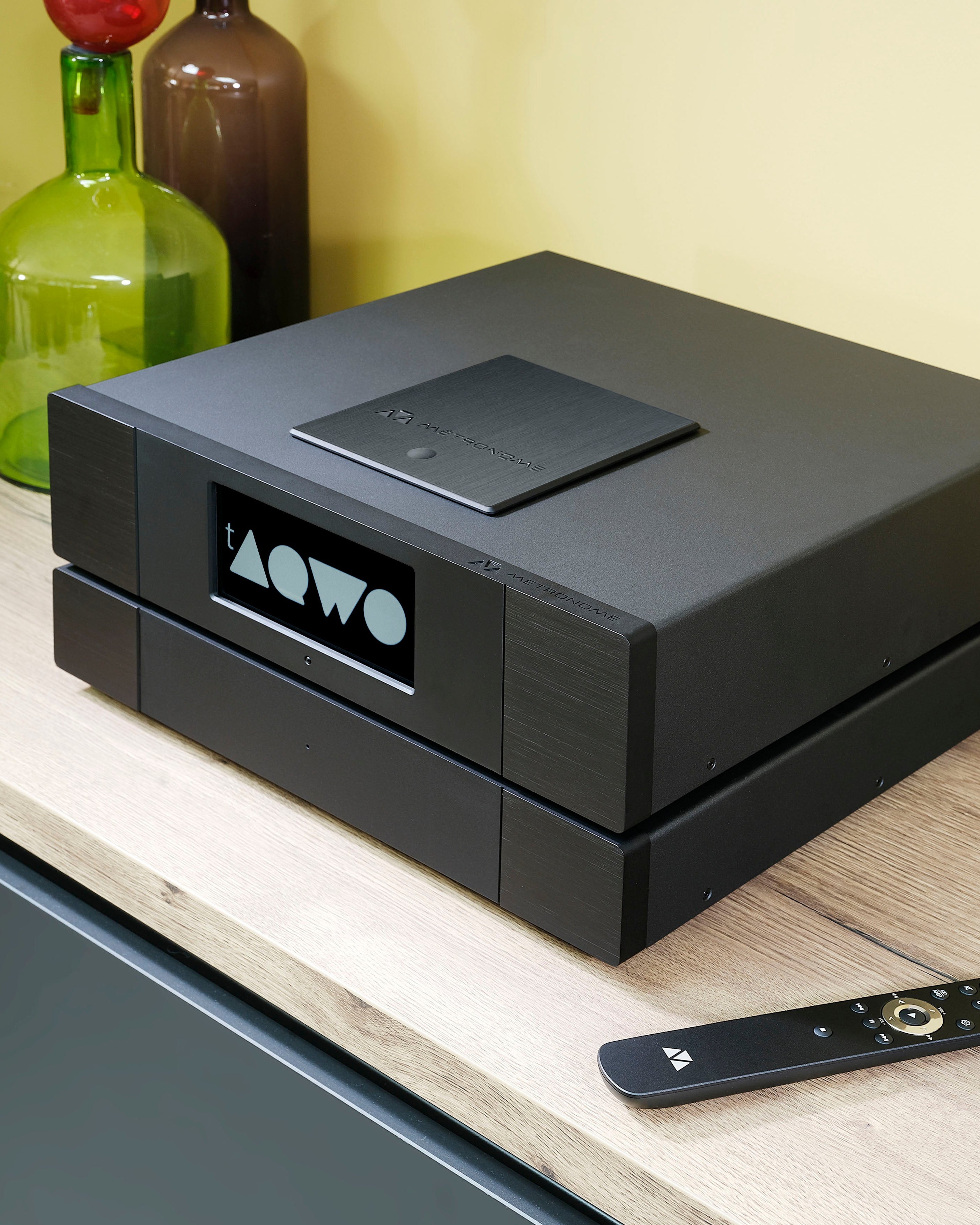 Metronome gamme aqwo on a wooden surface with a remote control.