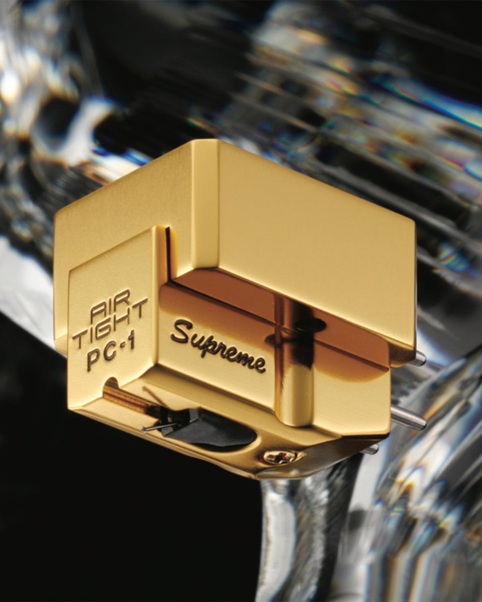 Air tight gold phonograph record player cartridge with 'Supreme' branding on a reflective background