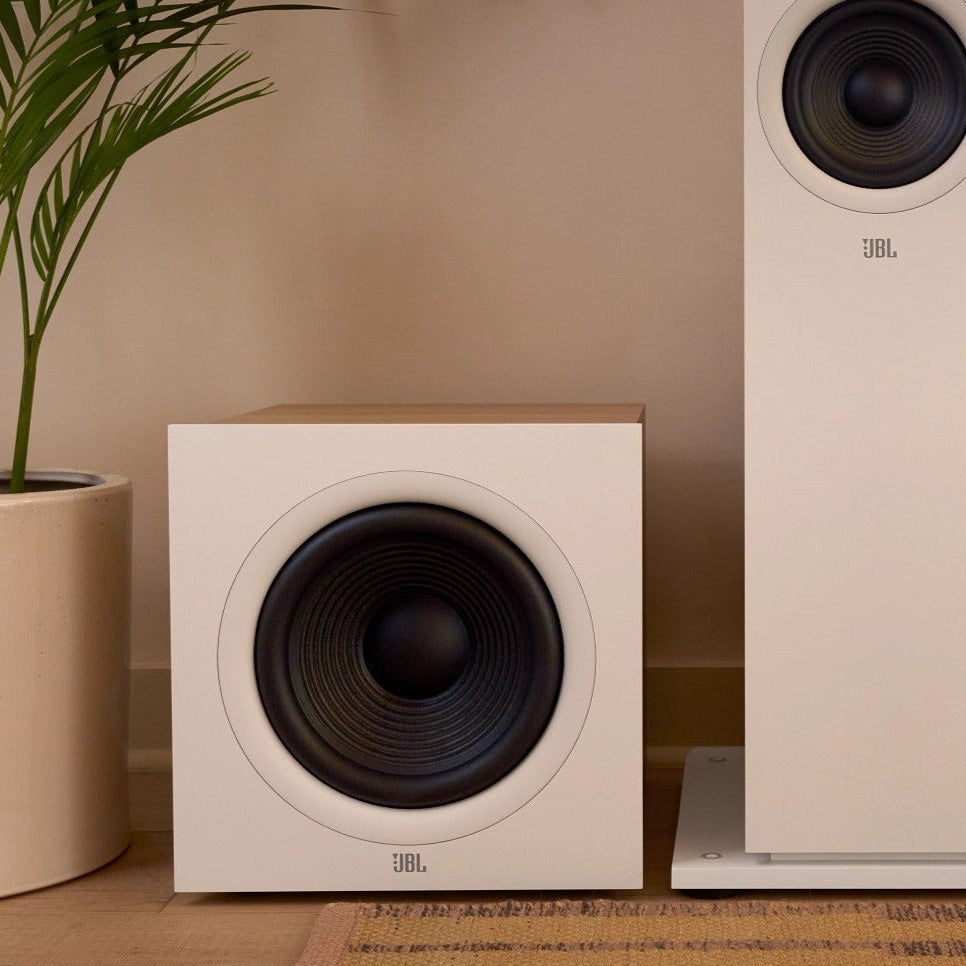 JBL Stage2 200P Powered Subwoofer on a wooden floor with a plant in the background